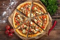 Homemade vegan pizza with tomatoes, zucchini, bell peppers, mushrooms and soy meat on an old wooden table. Top view Royalty Free Stock Photo