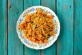 Homemade vegan pumpkin pilaf in colorful plate on turquoise tabl