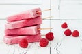 Homemade vegan raspberry coconut milk popsicles - ice pops - paletas with chia seeds on rustic white wooden background.