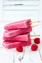 Homemade vegan raspberry coconut milk popsicles - ice pops - paletas with chia seeds on rustic white wooden background.