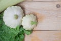 Homemade vegetables. Squash Squash white and lettuce on a wooden background. Green harvest on wooden background. Courgettes on a