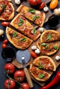 Homemade vegetarian pizza party. Flat lay of rustic pizzas with leek, mushrooms, tomatoes and basil served with wine, raw Royalty Free Stock Photo