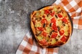 Homemade vegetarian pizza with tomatoes, mushrooms and pickled cucumbers, cheese and tomato sauce on a round wooden cutting board Royalty Free Stock Photo