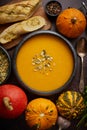 Homemade vegetarian pumpkin cream soup served in ceramic bowl. Decorated with seeds