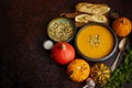 Homemade vegetarian pumpkin cream soup served in ceramic bowl. Decorated with seeds