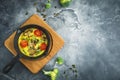 Homemade vegetarian soup in white bowl on dark backgroundHealthy vegetarian omelet in frying pan and pumpkin seeds. Flat lay, top