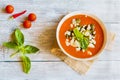 Homemade vegetarian tomato soup with feta cheese and pesto sauce in white bowl on wooden background Royalty Free Stock Photo