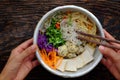 Homemade Vietnamese vegan noodles soup with colorful vegetables, people hand hold bowl to ready to eat