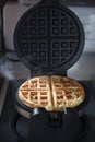 Homemade waffle cooking in waffle iron