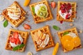 Homemade waffle with a cream, a variety of fruits, berries and sauces on a gray background. Traditional Belgian waffles. Top view Royalty Free Stock Photo