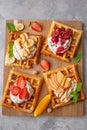 Homemade waffle with a cream, a variety of fruits, berries and sauces on a gray background. Traditional Belgian waffles. Top view Royalty Free Stock Photo