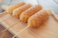 Homemade Waffle sausage sticks on wooden dish ready to serve and wooden table background . Trendy bakery street food