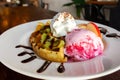 Homemade waffle served with stawberry ice cream and variety fruit. Sweet and crunchy dessert.