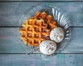 Homemade waffles with ice cream balls on a glass plate on a wooden table Royalty Free Stock Photo