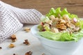 Homemade waldorf salad made of celery, apples and walnuts, served on a bed of fresh leaf lettuce