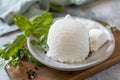 Homemade whey ricotta cheese or cottage cheese with basil ready to eat. Vegetarian healthy diet, fermentation food concept