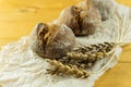 Homemade whole grain bread, wheat grains and spikelets. Wheat spikelets and bread. Spikelets of fresh wheat bread on a brown Royalty Free Stock Photo