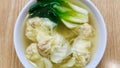 Shrimp Wanton Noodle Soup with vegetable in a white bowl on at wooden brown table. Royalty Free Stock Photo