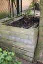 Homemade wooden compost bin in the garden. Recycling organic biodegradable material and household waste in composter. Best organic