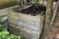 Homemade wooden compost bin in the garden. Recycling organic biodegradable material and household waste in composter. Best organic