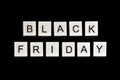 A homemade wooden tile with letters on a black background, word black friday