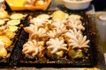 Homemade & x22;Baby Octopus& x22; in Takoyaki Japanese balls on black stove - for Japanese food background or texture. Royalty Free Stock Photo