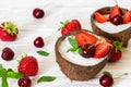 Homemade yogurt with chia seeds, berries and mint in coconut bowls over white wooden table. healthy breakfast. Royalty Free Stock Photo