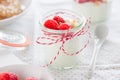 Homemade yogurt dessert with raspberries and crushed cookies in a small jar on a kitchen background Royalty Free Stock Photo