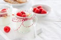 Homemade yogurt dessert with raspberries and crushed cookies in a small jar on a kitchen background Royalty Free Stock Photo