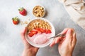 Homemade yogurt with fresh strawberries and muesli. The concept of a healthy Breakfast. Hands in shot Royalty Free Stock Photo