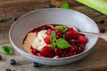 Yogurt or Quark with red berries on wooden table Royalty Free Stock Photo