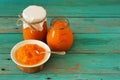 Homemade yummy pumpkin jam in glass jars and in white plate with