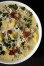 Homemade Zuppa Toscana with Kale and Bread in a white bowl on a black background, top view. Overhead, from above, flat lay. Close- Royalty Free Stock Photo