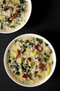 Homemade Zuppa Toscana with Kale and Bread in a white bowl on a black surface, top view. Overhead, from above, flat lay Royalty Free Stock Photo