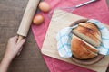 Homemaker holding rolling pin with sliced homemade bread on wood