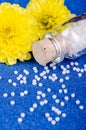 Homeopathic globules on a blue background with yellow flowers
