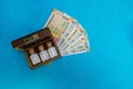 Homeopathic globules in glass bottles, calculator and Indian currency on blue background.Homeopathic Medicine and money concept