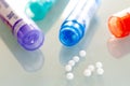 Homeopathic globules scattered around with their colored containers Royalty Free Stock Photo