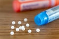 Homeopathic globules scattered around with their colored containers Royalty Free Stock Photo