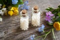 Two bottles of homeopathic remedy with flowers on a wooden table Royalty Free Stock Photo