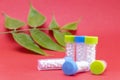 Homeopathy Concept - Homeopathic lactose sugar globules in bottles on pink background with green leaf