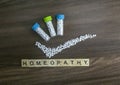 Homeopathy concept. Homeopathic medicine bottle with right mark and Homeopathy text on wood background