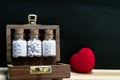 Homeopathy for heart concept Ã¢â¬â Close view image of homeopathic medicine bottles consisting pills in wooden old box and heart on Royalty Free Stock Photo