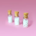 Homeopathy pills in vintage bottles on pink background