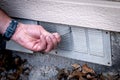 Homeowner actuates a foundation vent in his house Royalty Free Stock Photo