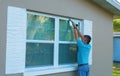 Homeowner caulking window weatherproofing home against rain and storms Royalty Free Stock Photo