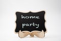 Home party written on a black chalkboard with wooden frame