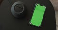 HomePod Mini speaker - the smart speaker on the table and smartphone with green screen. Concept of a smart home. Royalty Free Stock Photo