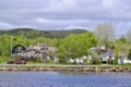 Homes along water with scenic landscape on the horizon along Newfoundland highway Royalty Free Stock Photo