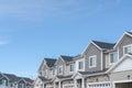 Homes with gable roofs and gray exterior walls against blue sky in the suburbs Royalty Free Stock Photo